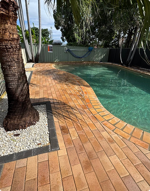 Brick-paved outdoor area beside a pool